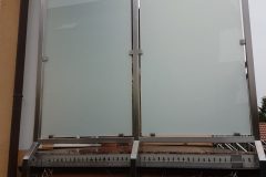Windfang mit VSG Glas mit matter Folie - Rahmen aus Edelstahlrohr, geschliffen Korn 240