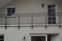 Geländer mit Kreuzen und Blumenkastenhaltern